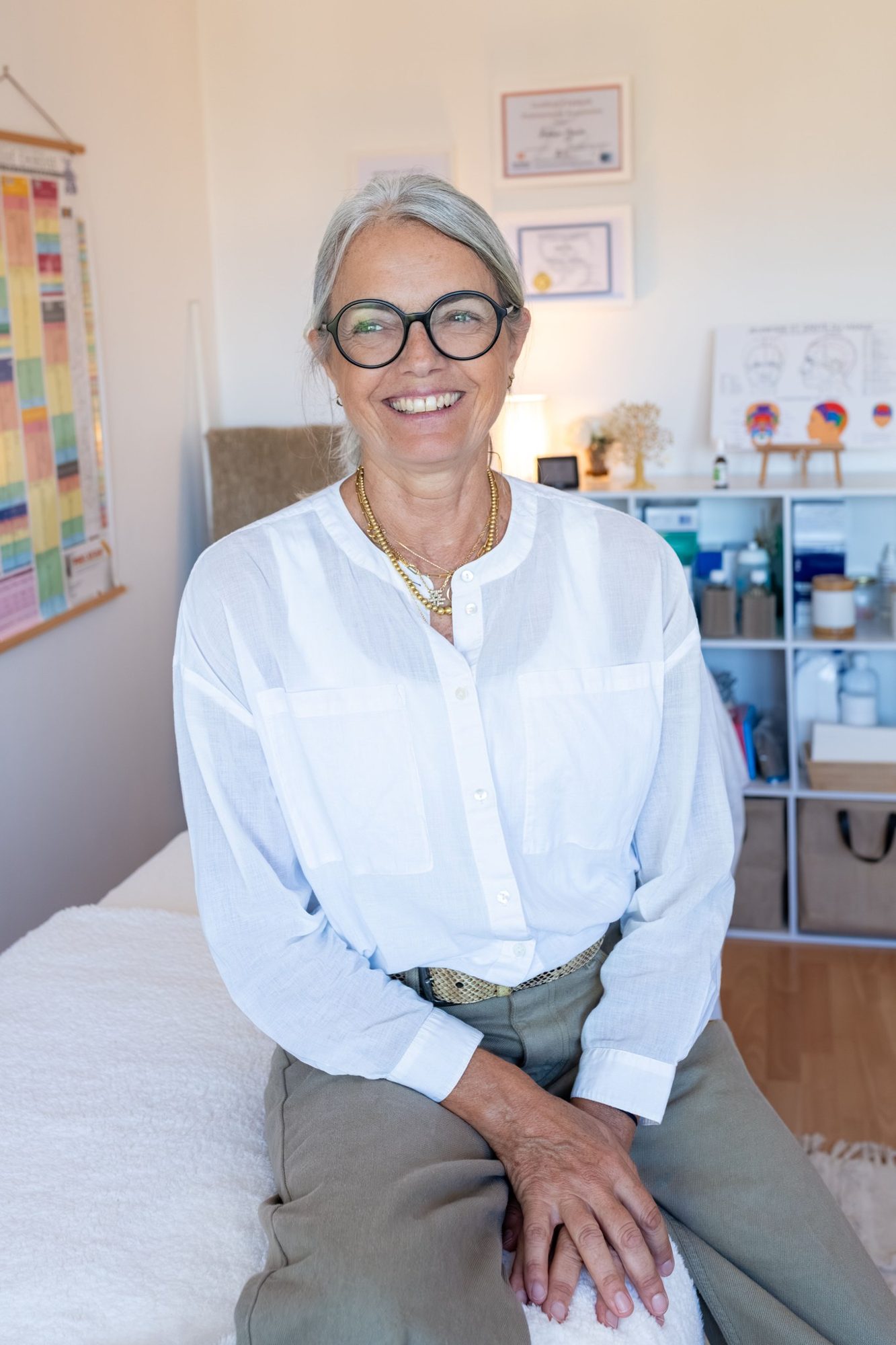 Frédérique Bruler assise sur la table de soin de son cabinet